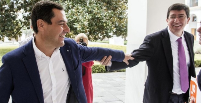 Juan Manuel Moreno Bonilla y Juan Marín se saludan en los pasillos del Parlamento andaluz. /EFE
