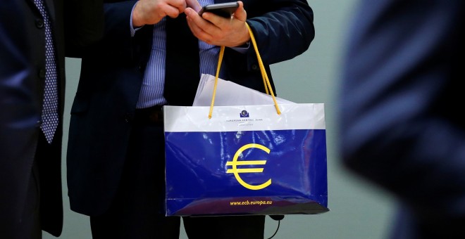 Un funcionario europeo lleva una bolsa con el logo del BCE. REUTERS/Francois Lenoir