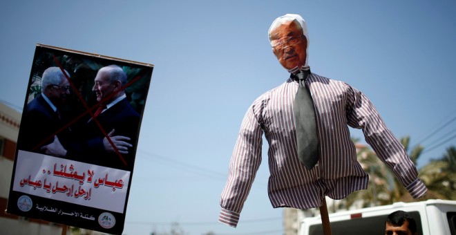 Un manifestante palestino sostiene una efigie que representa al presidente palestino Mahmoud Abbas. REUTERS