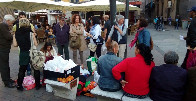 Voluntarios de Casa Solidaria reparten cenas en la plaza de Tirso de Molina de Madrid. / RAÚL GIGLIO