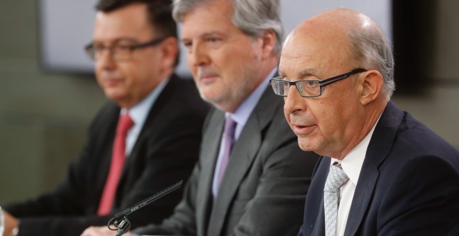 El ministro de Hacienda, Cristóbal Montoro, con el ministro  portavoz y de Educación Iñigo Méndez de Vigo, y el de Economía, Román Escolano, en la rueda prensa tras la reunión del Consejo de Ministros, en el Palacio de la Moncloa. EFE/Ángel DÍaz