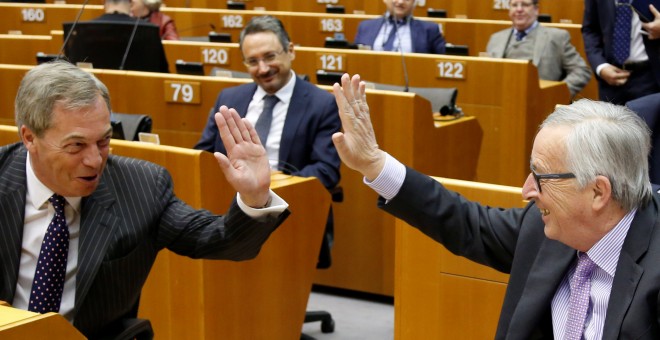El presidente de la Comisión Europea, Jean-Claude Juncker, saluda al eurodiputado euroescéptico Nigel Farage, antes del debate sobre el escenario presupuestario de la UE, en el Parlamento Europeo, en Bruselas. REUTERS/Francois Lenoir