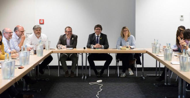 El expresidente de la Generalitat de Cataluña Carles Puigdemont (fondo-c), junto a la portavoz de JxCat, Elsa Altadi (fondo-d), y el vicepresidente primero de la Mesa del Parlament, Josep Costa (fondo-i),durante la reunión en Berlín con la práctica totali