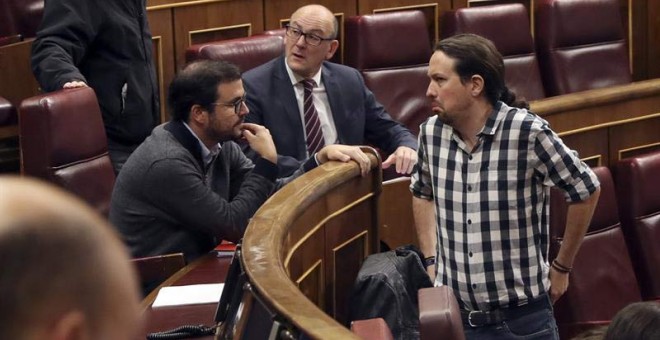 El secretario general de Podemos, Pablo Iglesias (d). conversa con el líder de IU, Alberto Garzón, durante un pleno del Congreso. (J.J. GUILLÉN | EFE)
