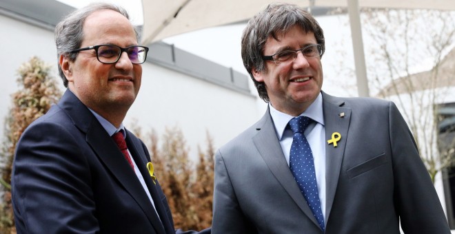 El recentment escollit President de la Generalitat de Catalunya, Quim Torra, es dona la mà amb el President cessat, Carles Puigdemont.