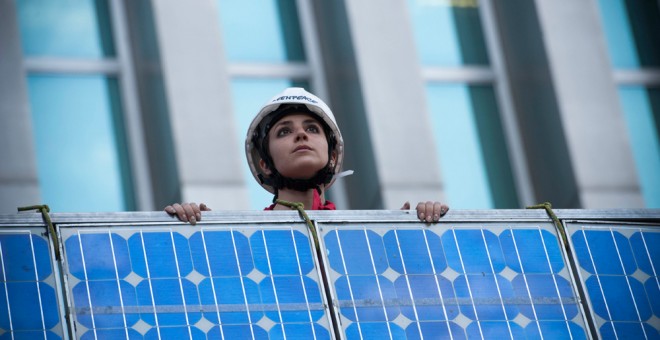 Activistas de Greenpeace subiendo una placa solar por la fachada del Ministerio. GREENPEACE