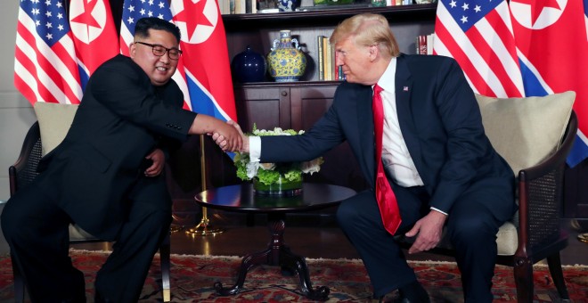 Kim Jong Un y Donald Trump estrechan sus manos antes de su conversación privada enmarcada en la cumbre celebrada en el Hotel Capella de la isla de Sentosa (Singapur). /REUTERS