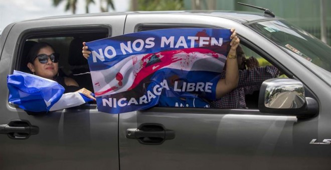 04/07/2018.- Un grupo de personas agita una bandera desde un vehículo durante un plantón denominado 'Cadena Humana de Rotonda a Rotonda', a una distancia 3.4 km en la carretera hacia Masaya, hoy, miércoles 4 de julio de 2018, en Managua (Nicaragua). Desde