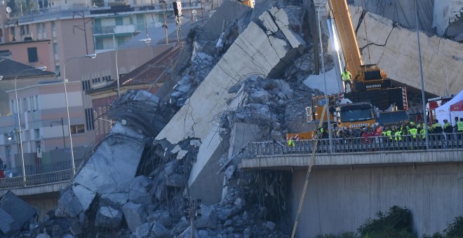 Una grúa trabaja en las labores de búsqueda de víctimas y retirada de los escombros del puente que el martes se desplomó en Génova (Italia). EFE/ Luca Zennaro