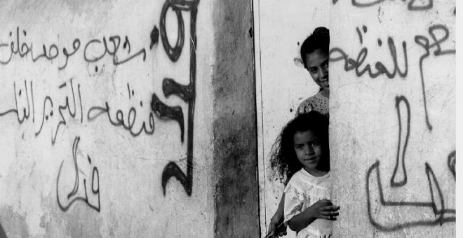 Foto del 1 de septiembre de dos niñas palestinas, en la localidad de Jericó. Los muros de sus casas tienen pintadas de la OLP a favor del acuerdo de paz con Israel. AFP/Yoav Lemmer