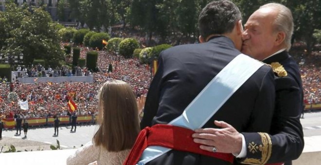 El rey emérito Juan Carlos recibe un beso de su hijo en el balcón del Palacio Real el día de la proclamación de Felipe VI. EFE