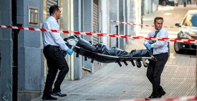 Operarios de los servicios funerarios retiran el cuerpo de la mujer asesinada por su marido en Bilbao. EFE/JAVIER ZORRILLA