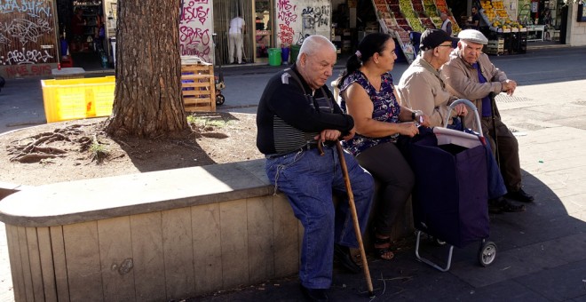 Varios pensionistas sentados en un banco en una plaza en Roma. REUTERS / Max Rossi