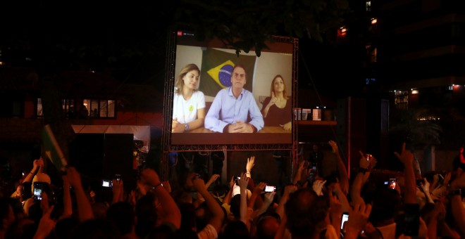 Seguidores de Bolsonaro siguen su discurso por una pantalla tras ganar las elecciones en Brasil. /REUTERS