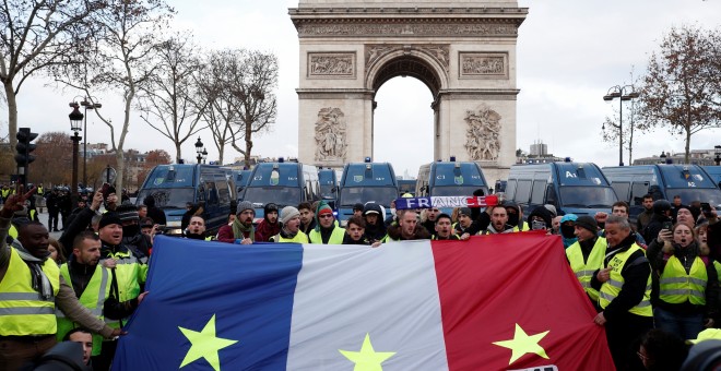 Manifestantes de los chalecos amarillos portan una bandera de Francia con tres fechas señaladas en cada franja: 1789, 1968 y 2018. REUTERS/Benoit Tessier