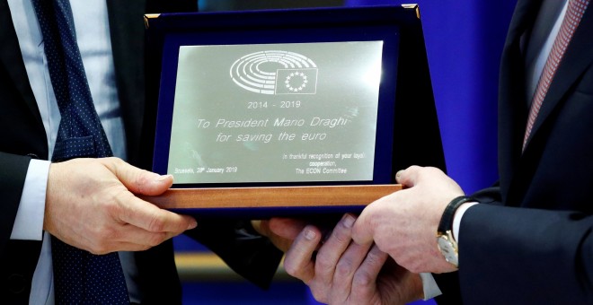 El presidente del Banco Central Europeo, Mario Draghi, recibe una placa de reconocimiento 'por salvar el euro' de manos del presidente de la comisión de Asuntos Económicos de la Eurocámara, el socialdemócrata italiano Roberto Gualtieri, en su última compa