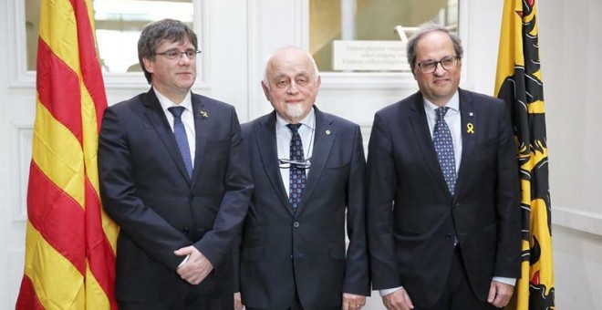 El president de la Generalitat de Catalunya, Quim Torra (d), l'expresident català Carles Puigdemont (i) i el president del Parlament de Flandes, Jan Peumans (c), davant les càmeres moments abans de la reunió celebrada aquest dilluns a la seu d'aquest orga