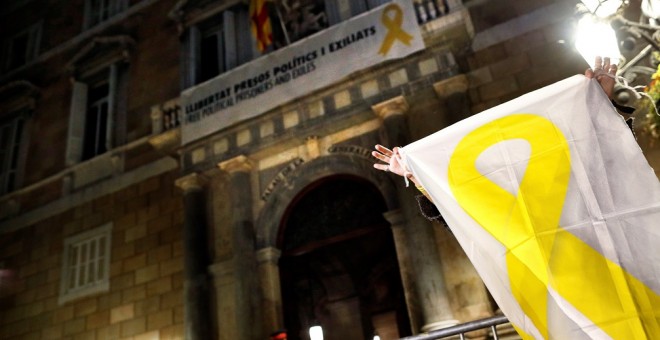 20/03/2019.- Una mujer muestra una pancarta con una lazo amarillo ante el Palau de la Generalitat. / EFE - ALEJANDRO GARCÍA