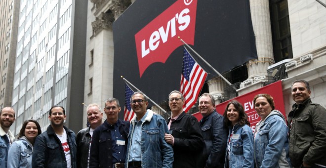 El equipo directivo de la marca de topa vaquera Levi Strauss posa delante del edificio de la Bolsa de Nueva York (NYSE, según sus siglas en inglés), en el primer día de cotización de la firma. REUTERS/Brendan McDermid