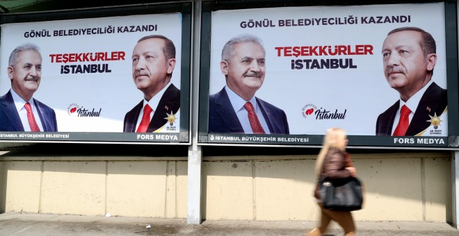 Gente pasea delante de carteles electorales del presidente turco, Recep Tayyip Erdogan, y del candidato de su partido Justicia y Desarrollo (AKP), Binali Yildirim, para la alcaldía de Estambul. EFE/ Erdem Sahin