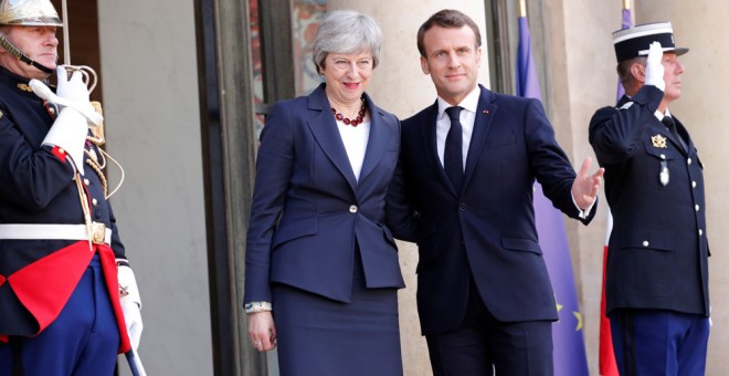 Emmanuel Macron saluda a Theresa May en el Palacio del Elíseo, en París. /REUTERS