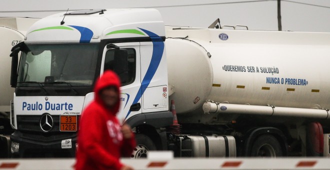 Un camión cisterna con el mensaje 'Queremos ser una solución, nunca un problema' en su tanque durante la huelga de transportistas de combustible, en Matosinhos, Portugal. EFE/ Estela Silva