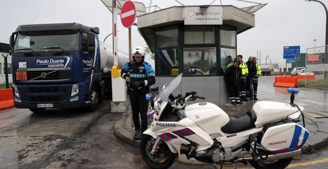 Un camión cisterna es escoltado por un policía a su llegada a la refinería de Leca da Palmeira en Matosinhos, con motivo de la huelga de transportistas de combustible en Portugal. EFE/ Estela Silva
