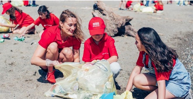 La nadadora olímpica Mireia Belmonte, embajadora del Santander para la limpieza de playas y cauces de ríos, junto a voluntarios del banco y sus familiares