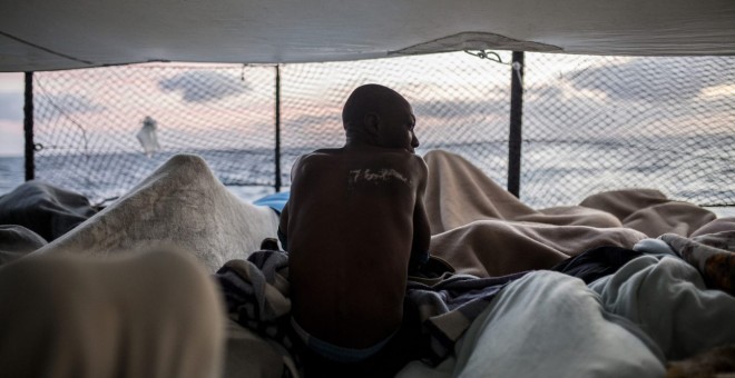 Saidou K., procedente de Sierra Leona, se despierta al amanecer en la cubierta del barco Open Arms en diciembre de 2018. Tras ser rescatados en el Mediterráneo central, el cierre de puertos italianos obligó a su traslado a Algeciras junto a otros rescatad