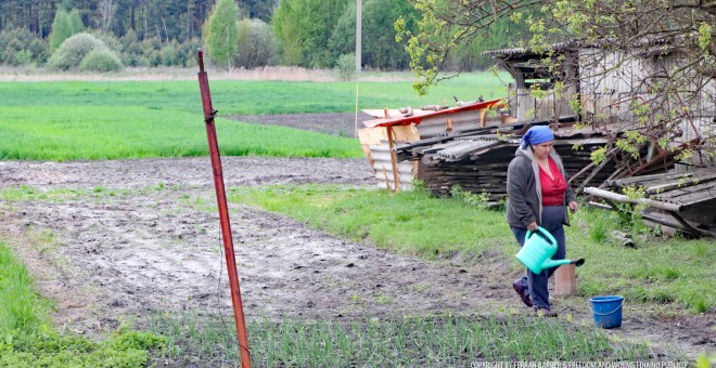 Una campesina de Zelena Polyana cultiva su huerto, a sólo tres kilómetros de los límites de la Zona Muerta. /FERRAN BARBER