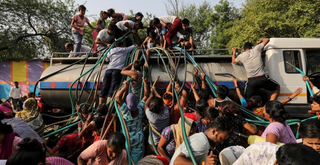 Residentes llenan recipientes de agua potable de una cisterna municipal en Nueva Delhi, el 1 de julio de 2019. REUTERS/Anushree Fadnavis