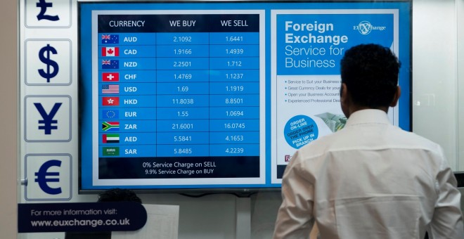 un hombre mira un monitor con los tipos de cambio de la libra frente a las principales divisas, en una ofician de cambio de moneda en el centro de Londres. EFE/EPA/WILL OLIVER