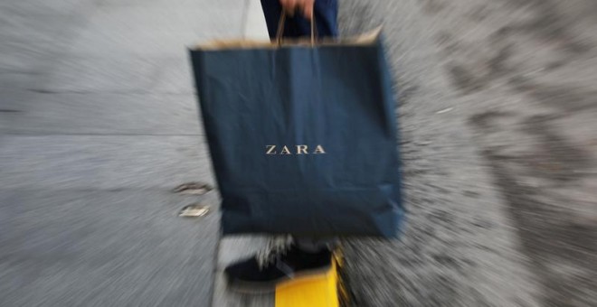 Un hombre sostiene una bolsa de Zara, la principal enseña de Inditex, en el centro de Madrid. REUTERS/Susana Vera