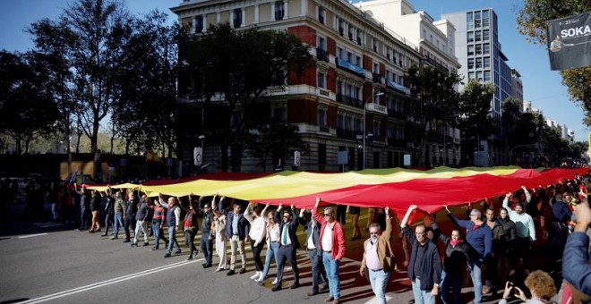 Decenas de personas portan la bandera de España de 1.000 metros cuadrados -50 de largo por 20 de ancho y con unos 130 kilos de peso, durante la concentración convocada por Vox para defender la 'unidad de España, el orden constitucional y la convivencia na