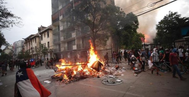 Manifestantes protestan en contra del Gobierno este viernes en la céntrica Plaza Italia en Santiago. EFE/Alberto Valdés