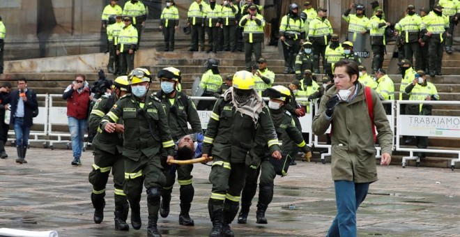 BOGOTÁ (COLOMBIA), 22/11/2019.- Miembros de los equipos de emergencia atienden a un herido durante un cacerolazo este viernes, en la Plaza Bolívar de Bogotá (Colombia). El rezago de las protestas de ayer en Colombia contra las políticas del Gobierno del p