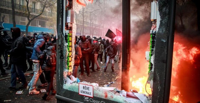 Manifestantes se enfrentan a la policía antidisturbios francesa durante una protesta contra la reforma de las pensiones, este jueves en París (Francia). Las pensiones se someten desde ayer a la prueba de la calle con una huelga que, en los transportes y o