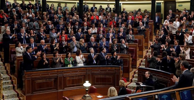Los diputados del PSOE y de Unidas Podemos (d) se aplauden mutuamente tras las intervenciones de los portavoces