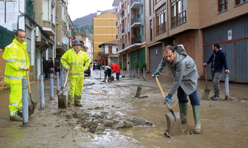 Vecinos de la localidad de Sodupe limpian las calles de tras las inundaciones del rio Herrerías a su paso por esta localidad que ha causado destrozos en viviendas y negocios. EFE/Luis Tejido