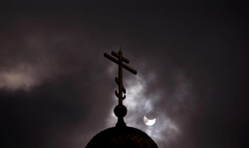 El eclipse parcial de sol entre las nubes, visto desde la cúpula de la Iglesia de San Nicolás, en Sofia (Bulgaria). REUTERS/Stoyan Nenov