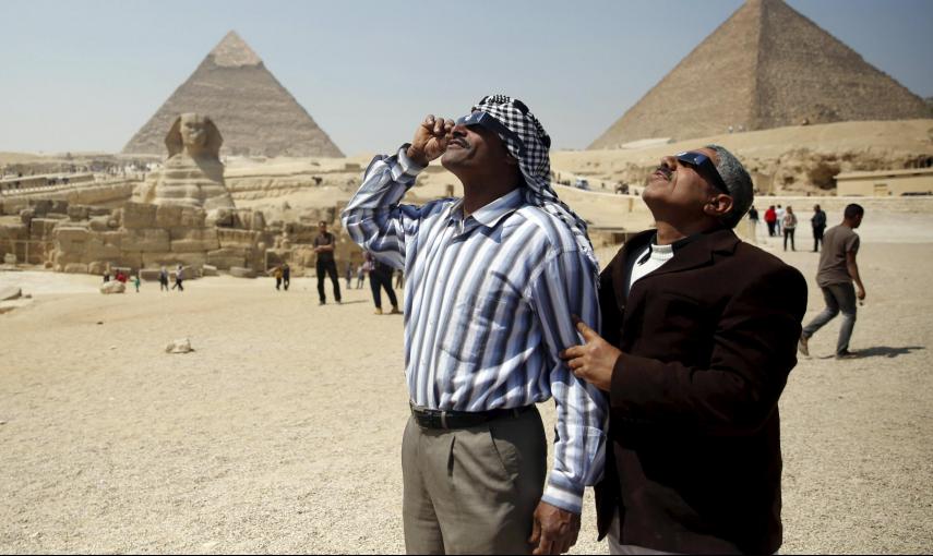 Dos personas observan el eclipse parcial de sol junto a las piramides, en El Cairo. REUTERS/Amr Abdallah Dalsh