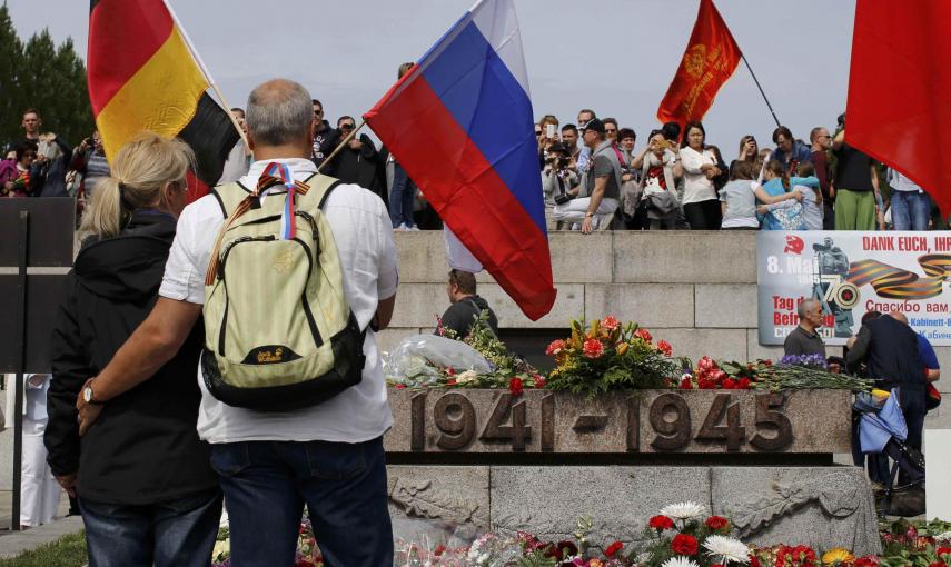 A couple holds a German and a Russian flag during celebrations to mark Victory Day, at the Soviet War Memorial in Treptower Park in Berlin, Germany, May 9, 2015. REUTERS/Fabrizio Bensch