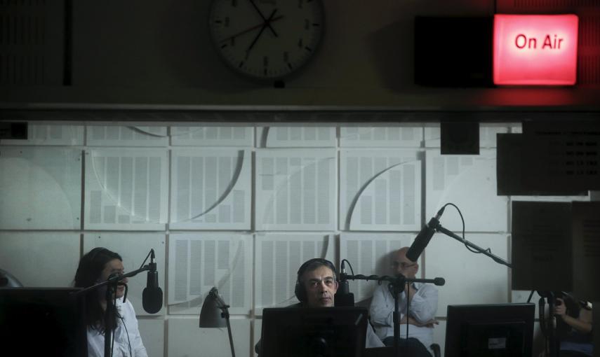 Presentadores de radio de la emisora ​​estatal griega ERT son vistos dentro de un estudio , durante la primera emisión de la estación después de su reapertura, en Atenas./ REUTERS/Alkis Konstantinidis