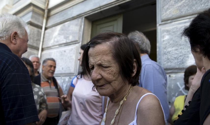 Varios jubilados se agolpan en una sucursal cerrada de Banco Nacional en Atenas. Tras el control de capitales establecido y el cierre de bancos, el Gobierno ha anunciado que abrirán para que los pensionitas puedan cobrar sus pensiones.- REUTERS / Marko Dj