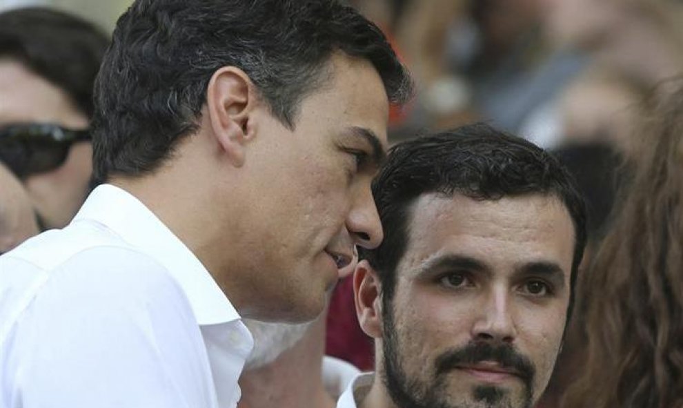 El secretario general del PSOE, Pedro Sánchez (i), conversa con el diputado de IU Alberto Garzón (d), al comienzo del tradicional desfile del Orgullo Gay.- EFE