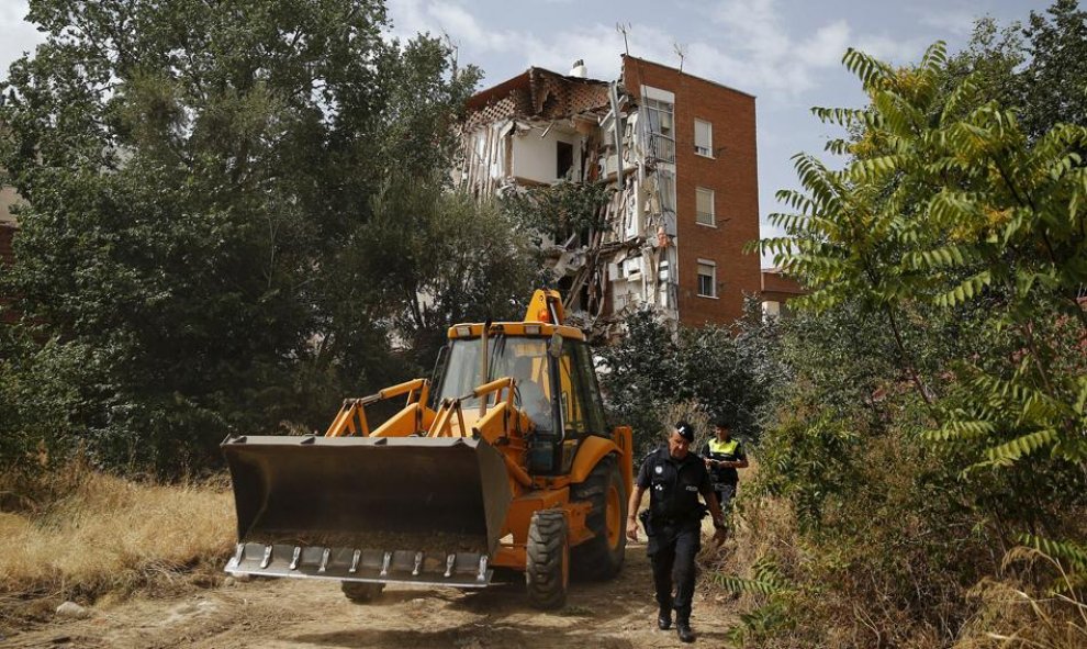 Policías y operarios junto al edificio que ha sufrido un derrumbe parcial en el barrio madrileño de Carabanchel.  REUTERS/Andrea Comas