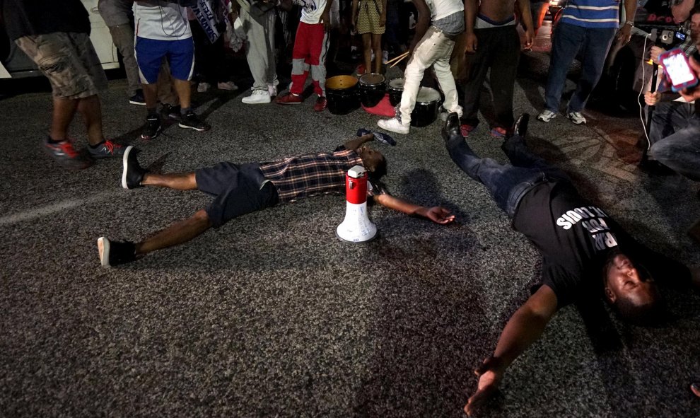 Dos jóvenes se tumban en el suelo para simular el asesinato, hace un año, del afroamericano Michael Brown. REUTERS / Rick Wilking