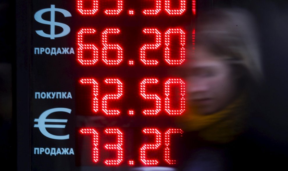 Una mujer pasea en Moscú frente a una pantalla que muestra el cambio de dólar y euros a rublos, la moneda rusa. REUTERS/Maxim Shemetov