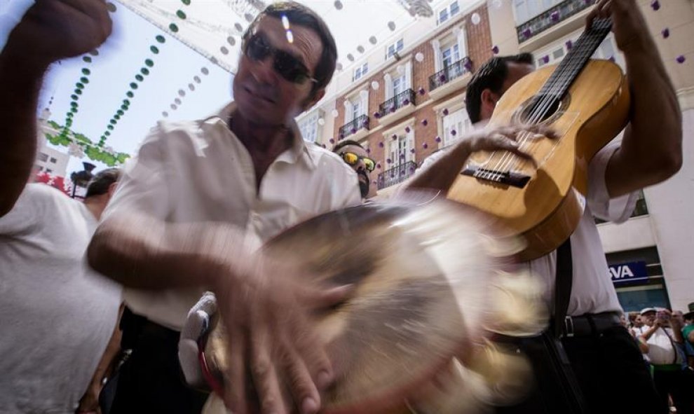 Una Panda de verdiales tocan sus instrumentos en la popular calle Larios en una jornada más en la feria del centro de Málaga, la gran fiesta del verano mediterráneo. EFE/Jorge Zapata