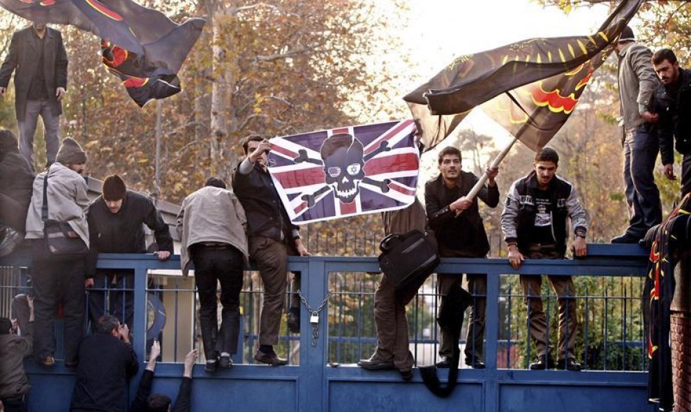 Varios estudiantes iraníes mientras intentan penetrar en la embajada británica durante una manifestación en Teherán, Irán. EFE/Abedin Taherkenareh